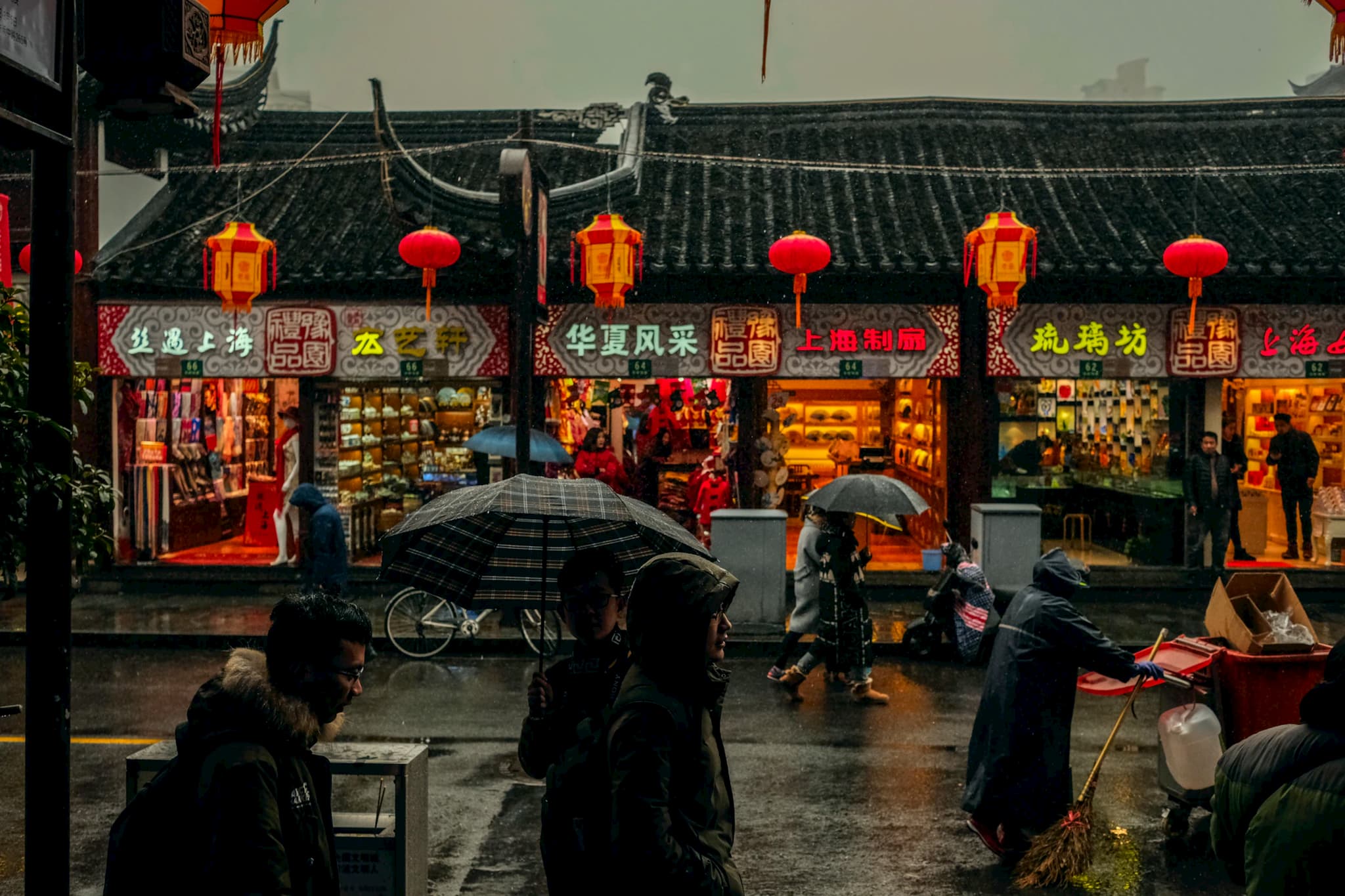 People walking and shopping in the rain in Shanghai, China.